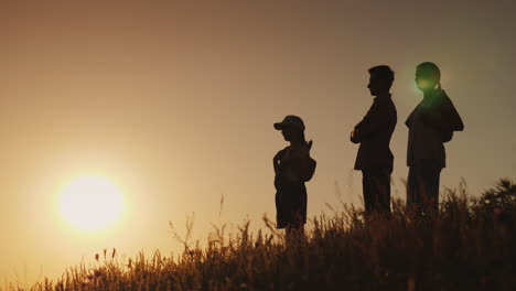 silhouettes of a happy family together they meet the dawn in a picturesque place 4k video