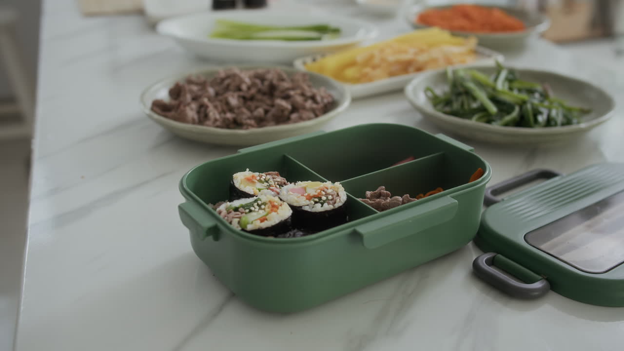 Sushi and Snacks in Lunchbox Left on Kitchen Table