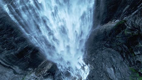 aerial top down shot showing falling water of waterfall into lake in norway - spectacular cinema footage