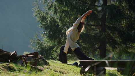 una mujer joven practicando yoga en la colina verde.