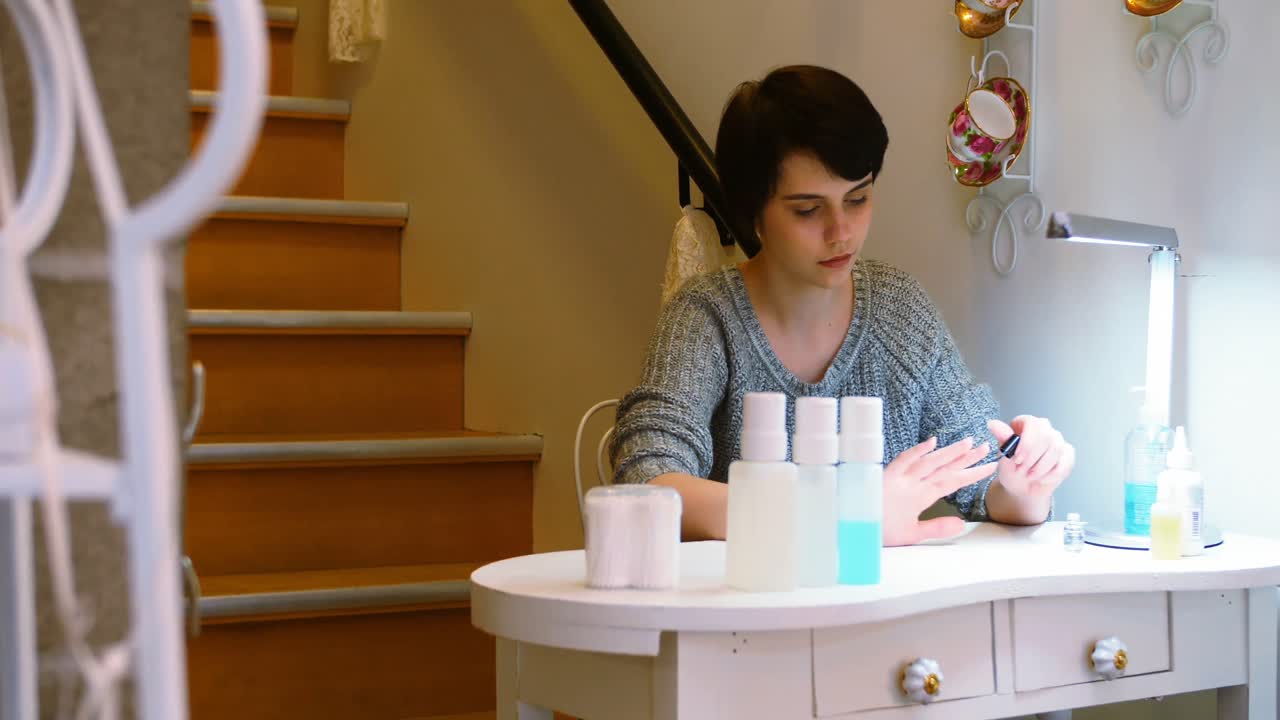 mujer aplicando esmalte de uñas a sus uñas