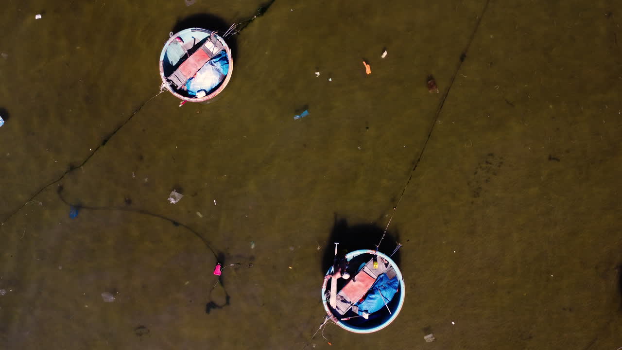 barcos de coracle redondos vietnamitas tradicionales sobre un ancla que se mueven lentamente sobre el agua ondulante