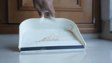 sweeping the floor with a brush and dustpan