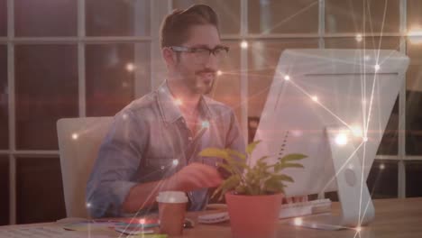 Glowing-network-of-connections-against-portrait-of-caucasian-man-using-computer-at-office