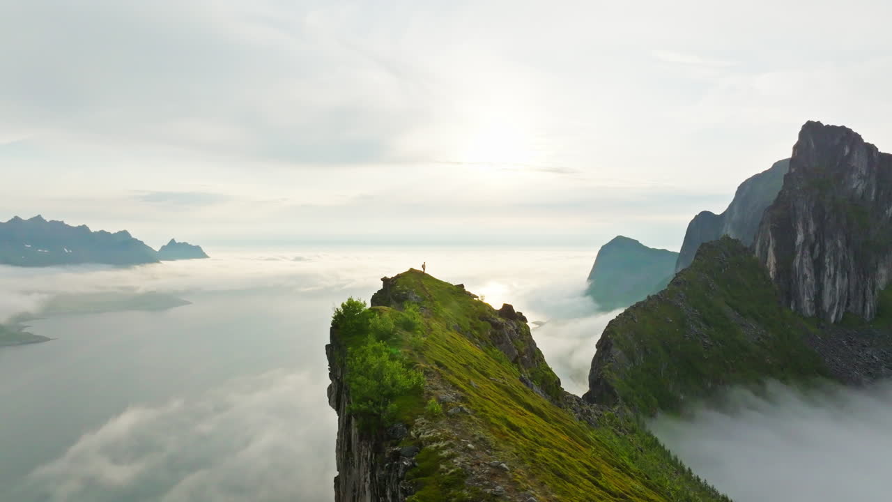 Lone hiker on Senja mountain ridge with majestic panorama seascape view