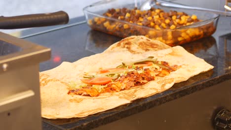 preparation of a chicken shawarma wrap with french fries