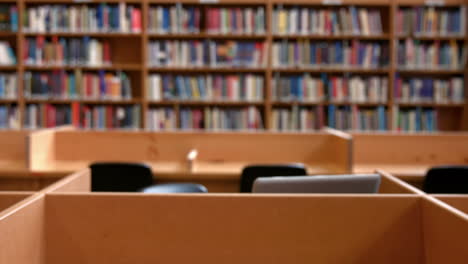 estudiante trabajando en una computadora portátil en la biblioteca