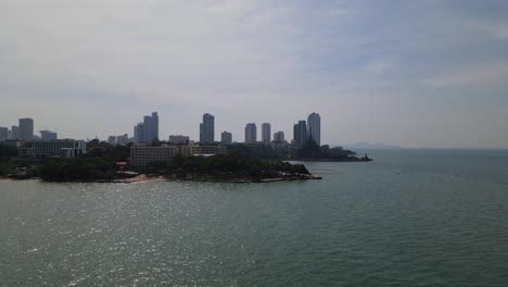 imágenes aéreas ascendentes de un hotel frente a la playa y el santuario de la verdad también los edificios en el fondo en pattaya, chonburi, tailandia