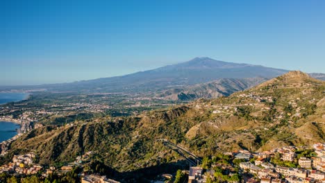 aerial hyperlapse of mount etna. church on the edge of a cliff in the foreground. verdant mountains in sicily landscape.