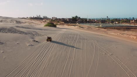 aerial: buggy driving through the dunes of cumbuco