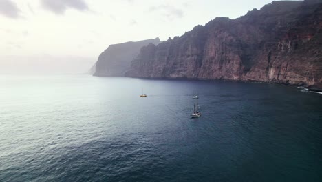 Luftaufnahme-Eines-Segelboots-In-Der-Nähe-Der-Klippenküste-Von-Los-Gigantes-Auf-Teneriffa