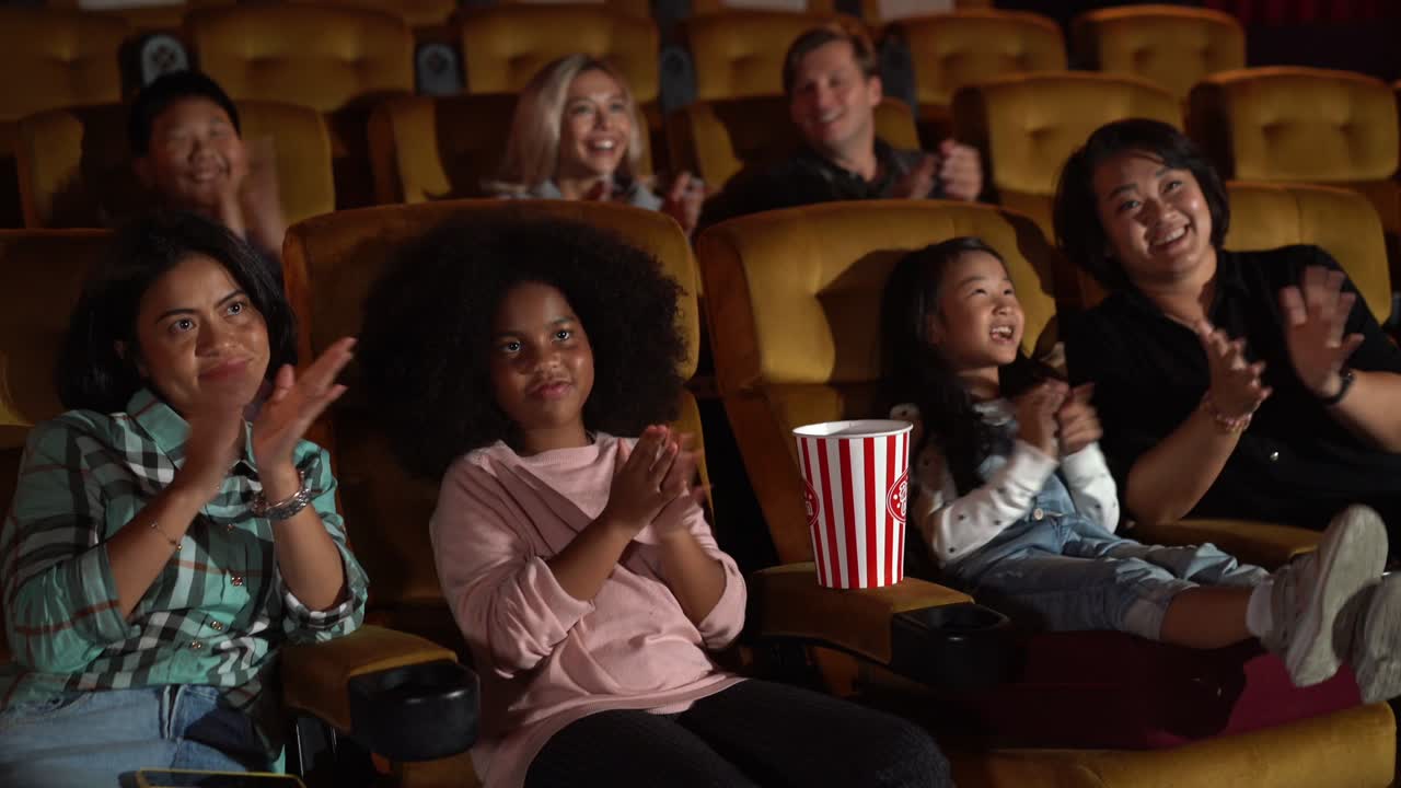 Spettatori che guardano un film al cinema.