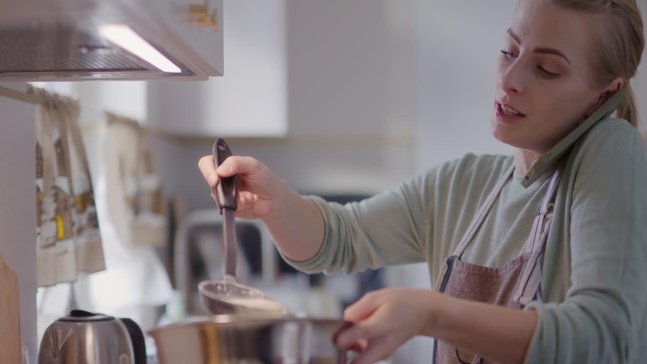음식 을 준비 하고 기면서 전화 로 대화 하는 부 에 바쁜 여자