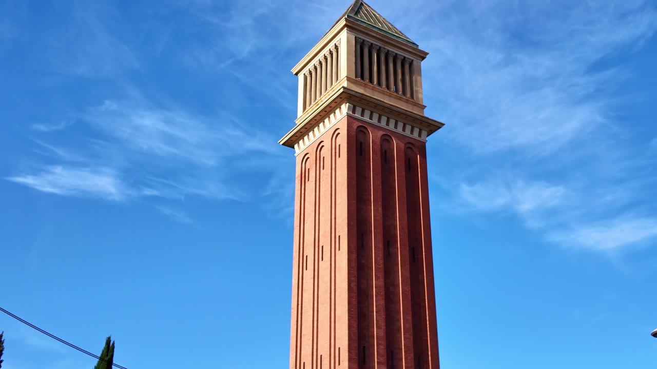 Low angle view of a historic Venetian Tower with clear blue sky in background, Plaça d'Espanya in Barcelona, Spain. Tilt-up