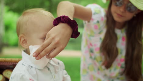 Junge-Sitzt-Mit-Schwester-Und-Mutter-Auf-Einer-Decke-Im-Park.-Familie-Ruht-Im-Wald