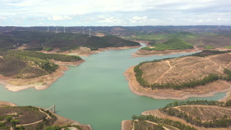 Aerial-View-Of-Odeleite-Dam-And-Barragem-da-bravura-Near-Wind-Farm-In-Castro-Marim,-Algarve,-Portugal
