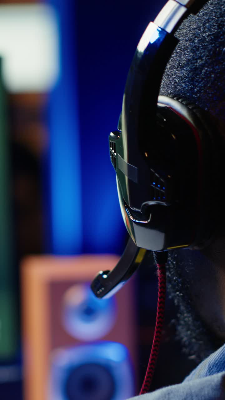 Vídeo vertical de homem usando fone de ouvido para jogar videogame SF FPS, se divertindo, close-up