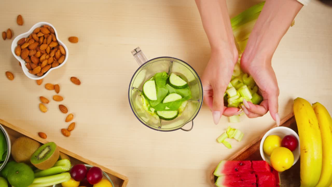 Toma cenital de manos cortando apio para un batido saludable