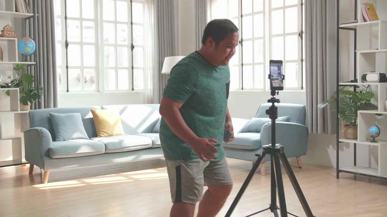 Blogger asiatico registra contenuti video per i social network con la fotocamera dello smartphone, mago con carte da gioco.