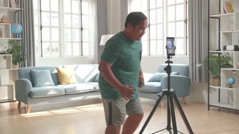 asian man blogger shoots video content for social networks by smartphone camera, magician with playing cards