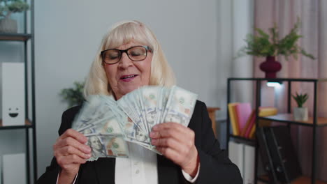 business woman accountant celebrating business success dancing with stack of money dollar cash