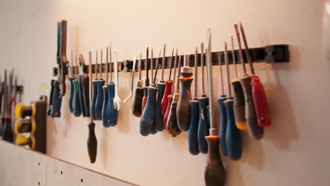 chisels, screwdrivers, wrench and pliers on wall in furniture assembly shop