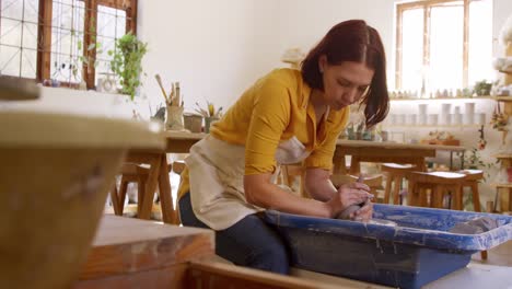 Young-female-potter-working-in-her-studio