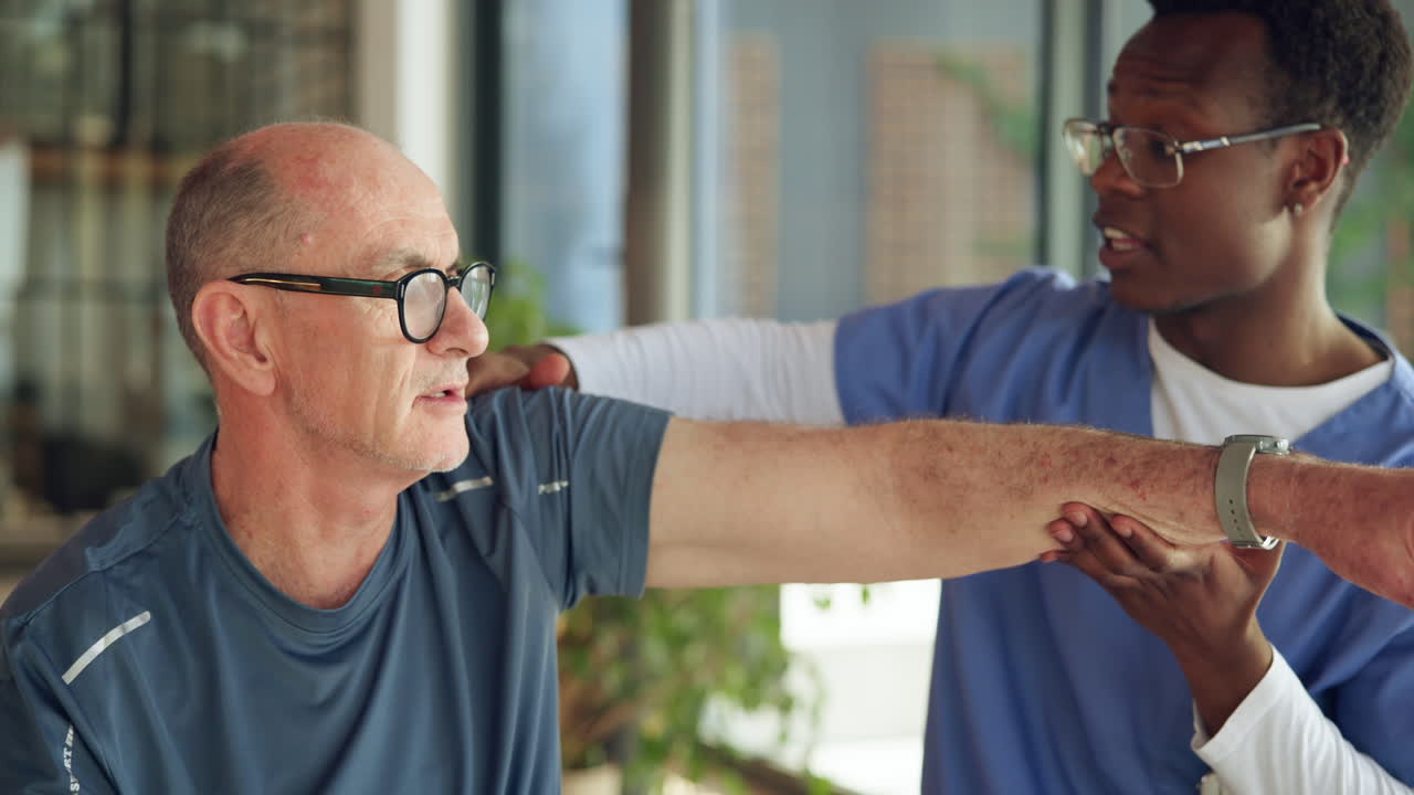 Physiotherapist Helps Elderly Man with Arm Rehabilitation Exercise