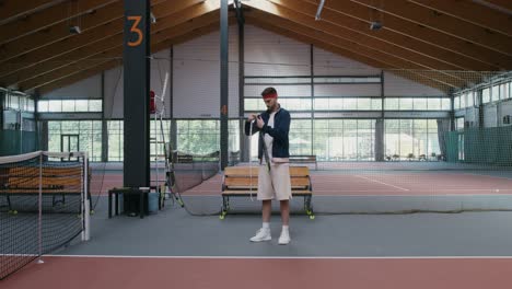 man stringing a tennis racquet on an indoor court