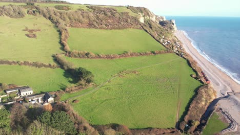 aerial forward shot of the coastline of where the fields meet the sea at branscombe devon england on a beautiful sunny day