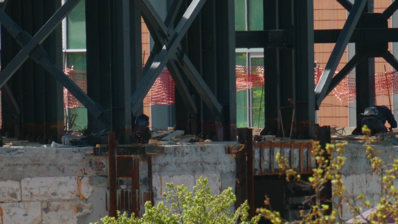Vista ravvicinata di travi d'acciaio e supporti strutturali in un cantiere edile attivo.