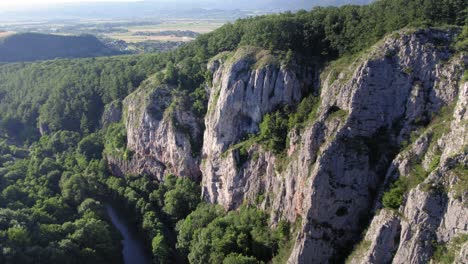 river next to giant limestone rock cliffs with a harsh sun