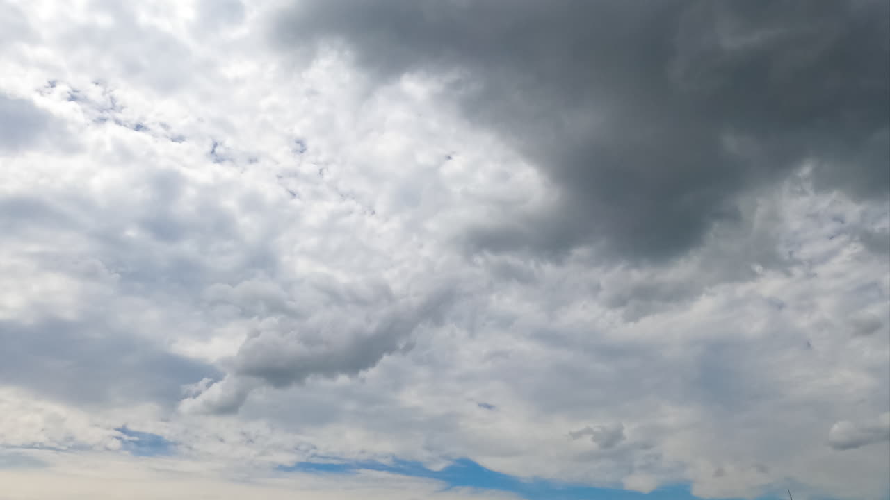 Cloudscape covering the skies and summer sun. Spindrift clouds spreading along the horizon. Low angle view timelapse.