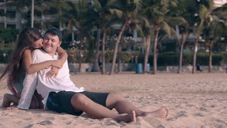 Emocionante-Pareja-Joven-Abrazos-Y-Besos-En-La-Playa-De-Arena