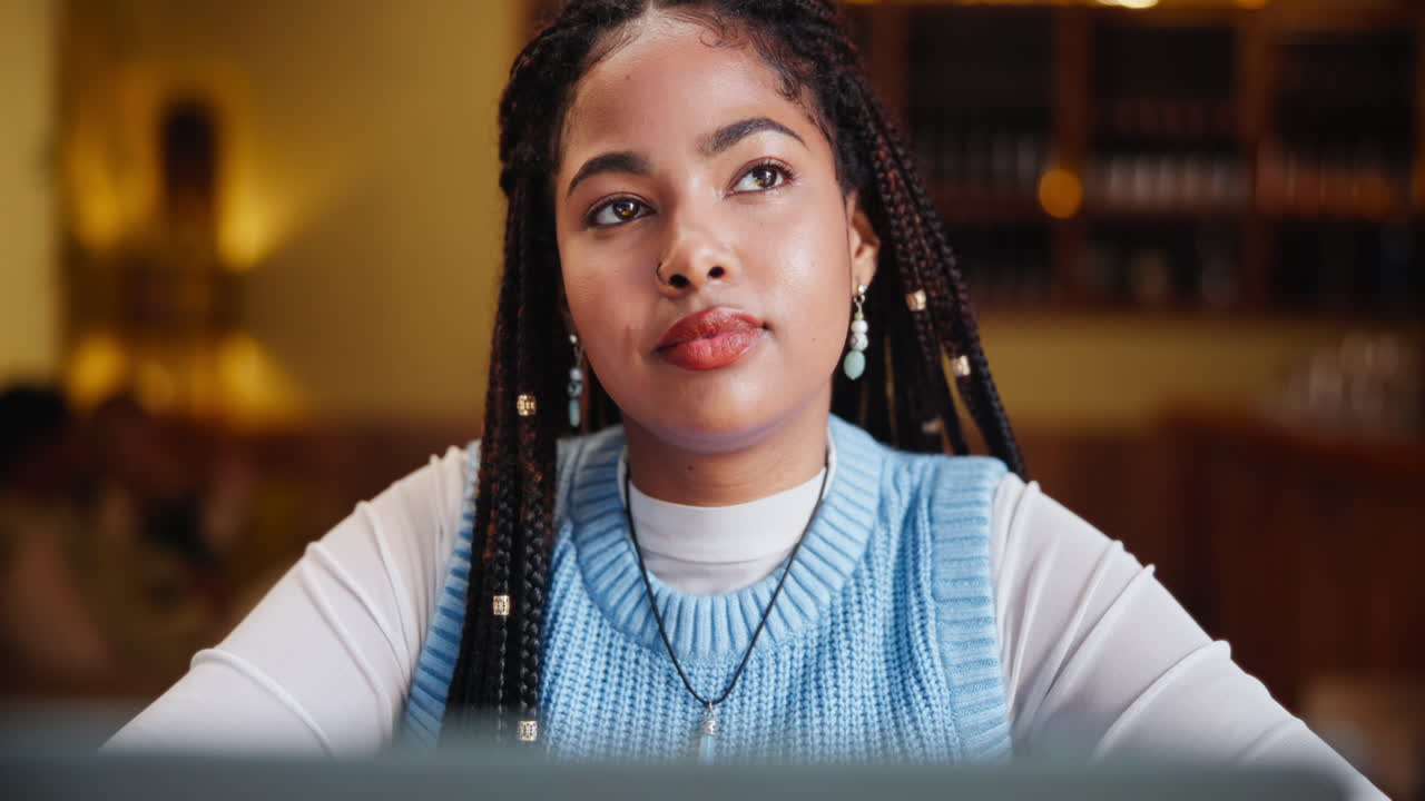 Woman with braids and sweater vest