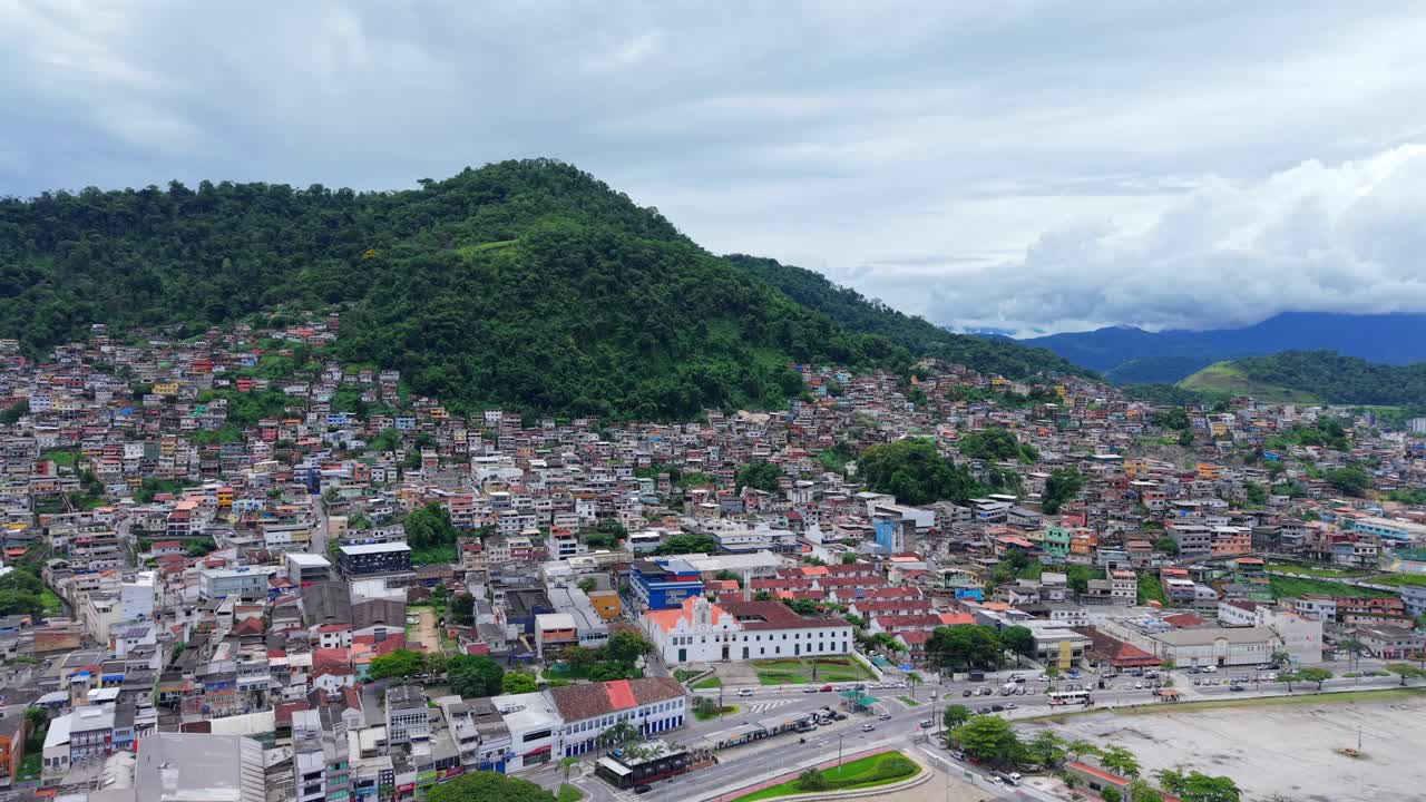 Trung tâm thành phố Angra dos Reis ở Rio de Janeiro, Brazil với Đại lộ Júlio Maria chạy dọc bờ sông và Nhà thờ Igreja Matriz de Nossa Senhora da Conceição hiện rõ trong khung cảnh sườn đồi rậm rạp, quay quét bằng drone.