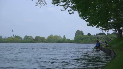 Japanese-fisherman’s-fishing-from-shore-of-lake-surrounded-by-nature