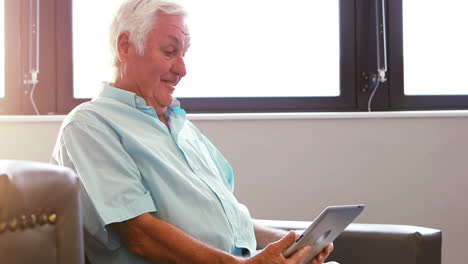 a senior man having a video conference with tablet pc