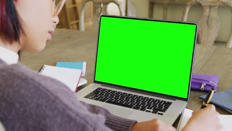 Composition-of-asian-schoolgirl-on-laptop-online-learning-with-green-screen