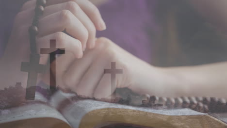 praying hands holding rosary beads over open bible with cross animation