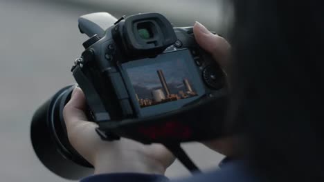 person holding a camera with cityscape in viewfinder