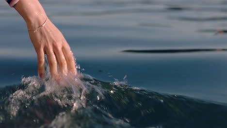 close up woman hand touching water waves splashing tourist enjoying boat ride