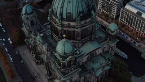 Tilt-down-close-up-footage-of-roof-and-facade-of-Berliner-Dom,-Evangelic-church.-Sightseeing-boat-floating-on-Spree-river.-Berlin,-Germany.