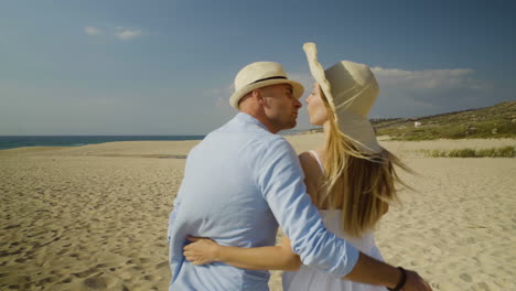 Couple-holding-hands-and-walking-on-beach