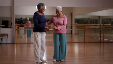 two senior african american women dancing or exercising in a studio