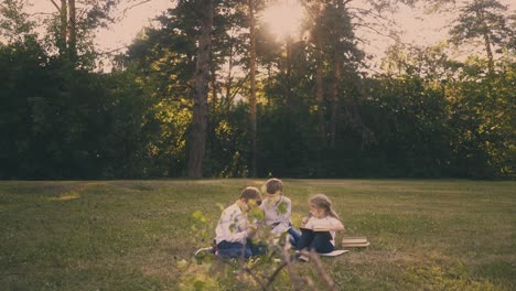 schoolboys prepare for exams with little girl in garden