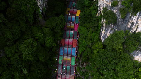 turistas subiendo por coloridos escalones empinados a las cuevas de batu en gombak, selangor, malasia