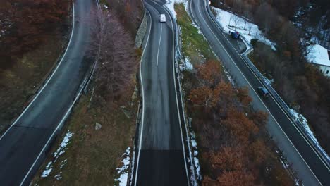 vehicles travelling through the windy roads of northern italy captured by drone