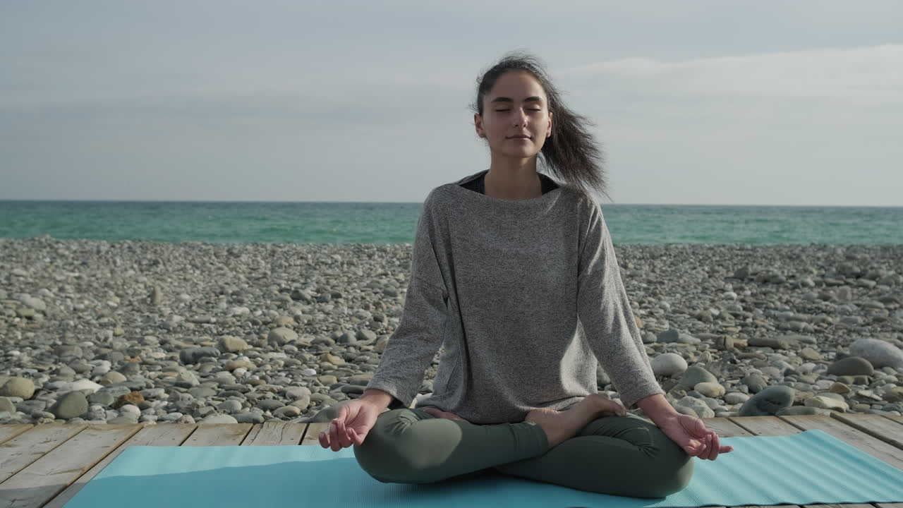 mujer meditando en una playa