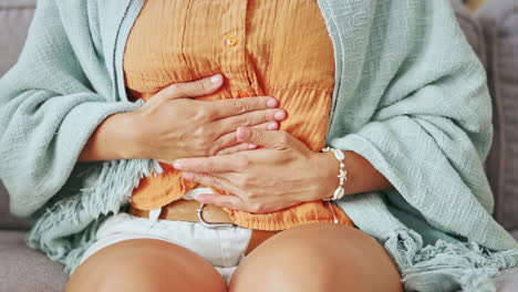 mujer enferma, dolor y manos en el estómago en la casa